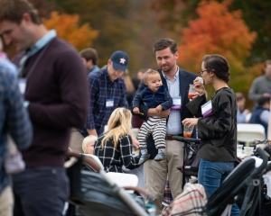 A young family at an outdoor meal at Young Alumni Weekend.